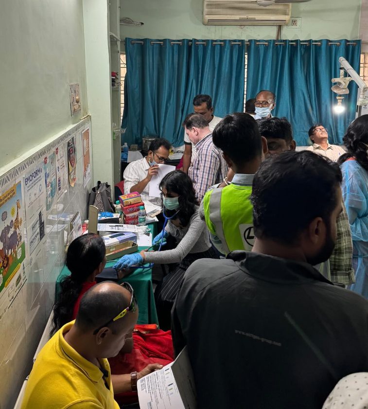 Volunteers and dentists screening a full room of patients